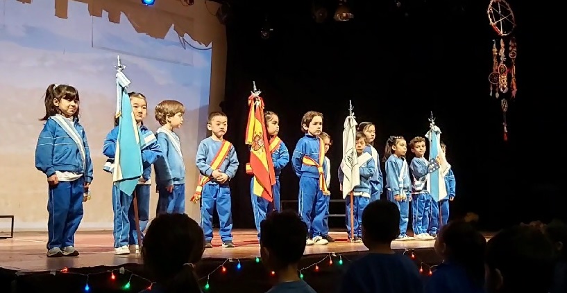 Niñas y niños del Nivel Inicial con banderas en un acto escolar