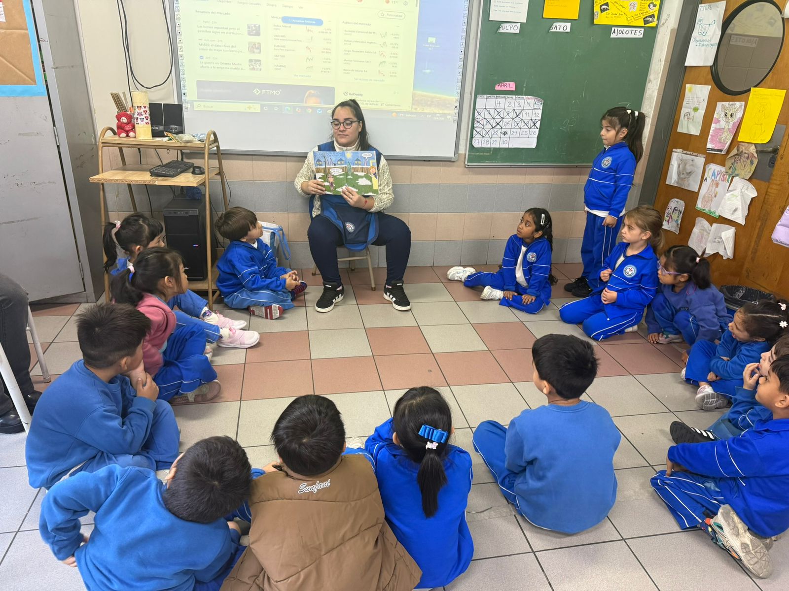 Docente leyendo un cuento a niñas y niños del Nivel Inicial sentados en ronda