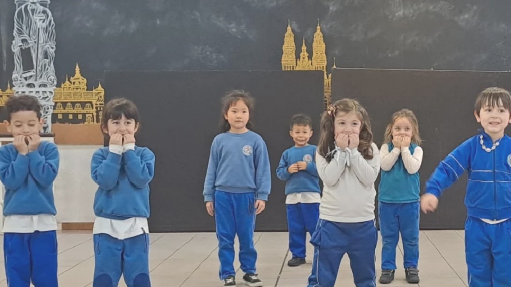 Niñas y niños del Nivel Inicial en un acto sobre el escenario del colegio