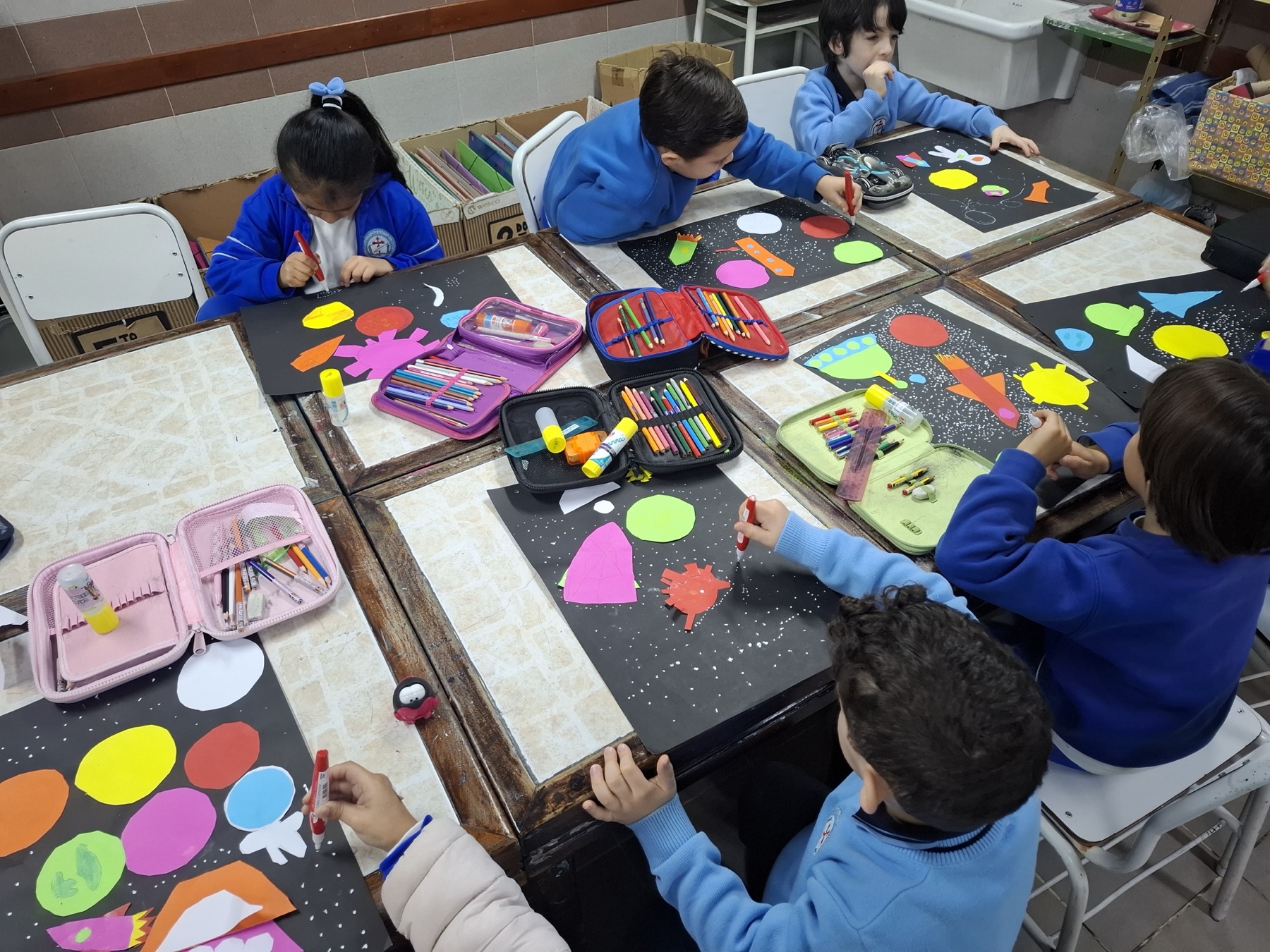 Estudiantes del Nivel Primario armando collages del espacio en el aula